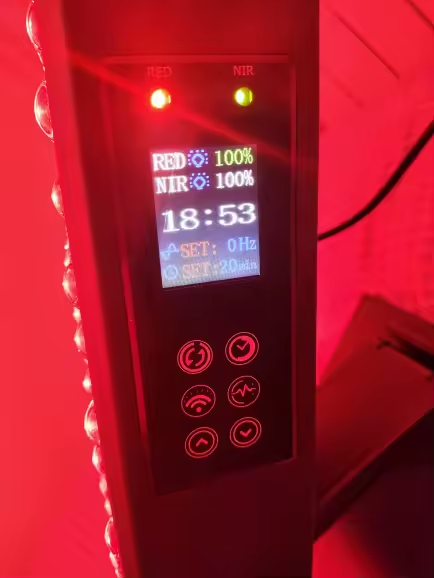 Tabletop LCD display showing 18:53 timer, RED 100%, NIR 100%