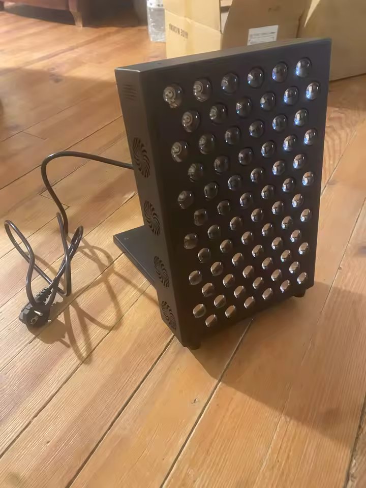 The Tabletop just unboxed on a wood floor, power cord visible, all 72 dual-chip LEDs visible in a 6 by 12 grid
