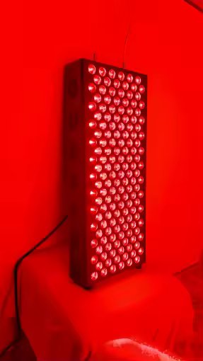 The Tower lit up at full intensity, all 150 dual-chip LEDs glowing red, standing on a chair in a customer's home